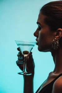 Elegant woman holding a martini glass, representing the sophistication and confidence of an elite London escort.