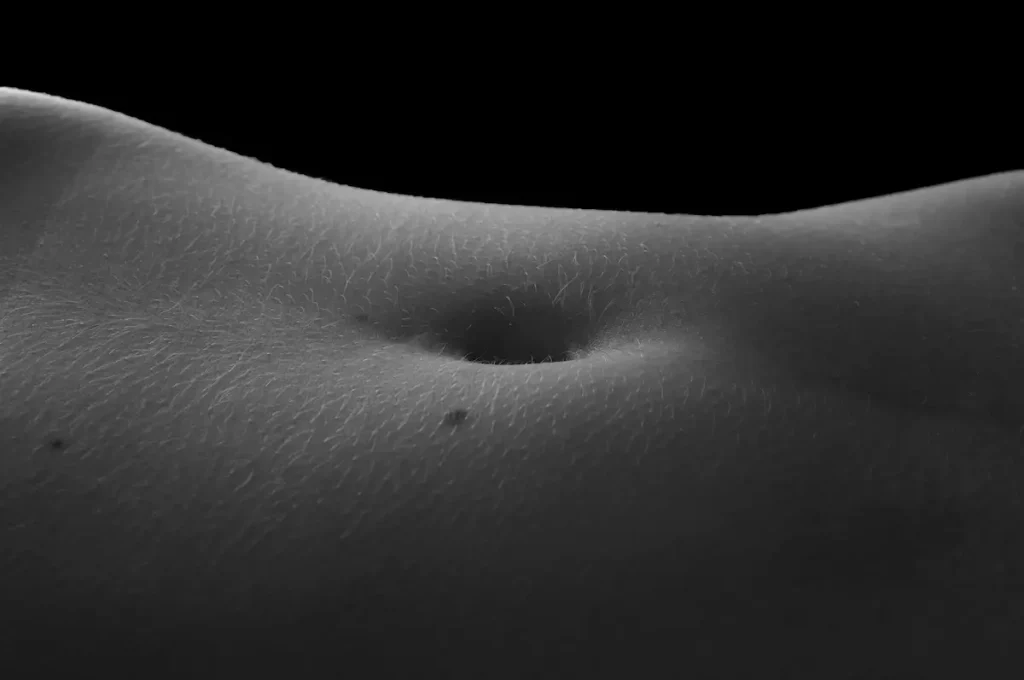 Close-up artistic photo of a person’s navel, highlighting skin texture and sensitivity as part of the 7 erogenous zones.