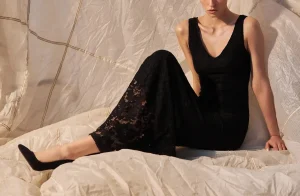 Elegant British London escort wearing a black lace dress in a refined setting