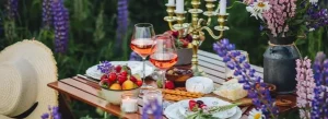 Elegant outdoor picnic setting with wine, fruit, flowers and candles, reflecting the refined lifestyle often associated with Elite Companion Services in London.