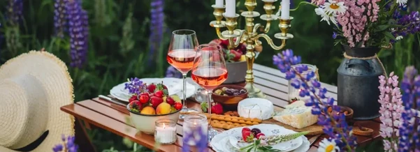 Elegant outdoor picnic setting with wine, fruit, flowers and candles, reflecting the refined lifestyle often associated with Elite Companion Services in London.