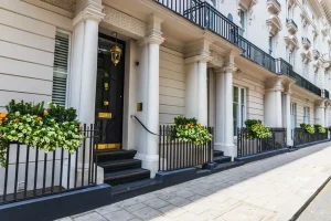 Elegant white stucco townhouses in a prestigious London neighbourhood, showcasing the high-class lifestyle in London.